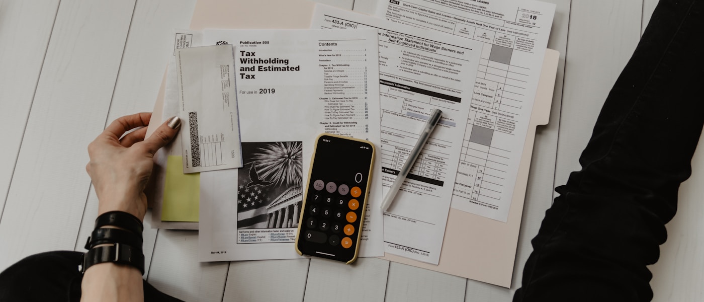 Person planning a personal budget with a laptop and financial notes